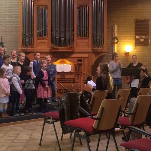 Gemeenteleden zingen samen voor in de kerkzaal van De Ark